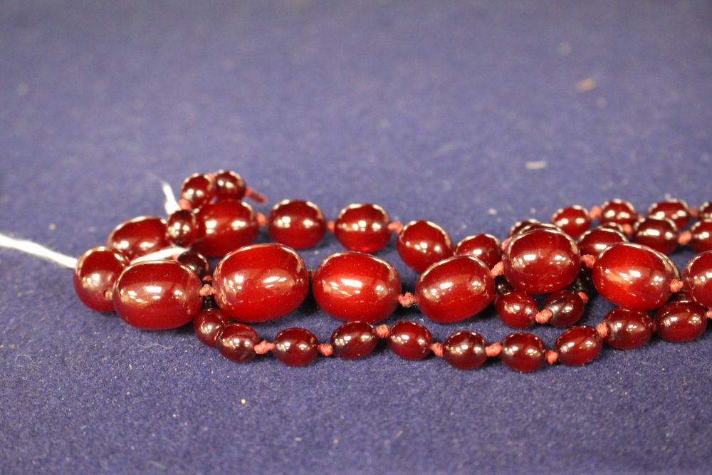 A single strand graduated simulated cherry amber bead necklace, gross weight 55 grams and assorted costume jewellery.